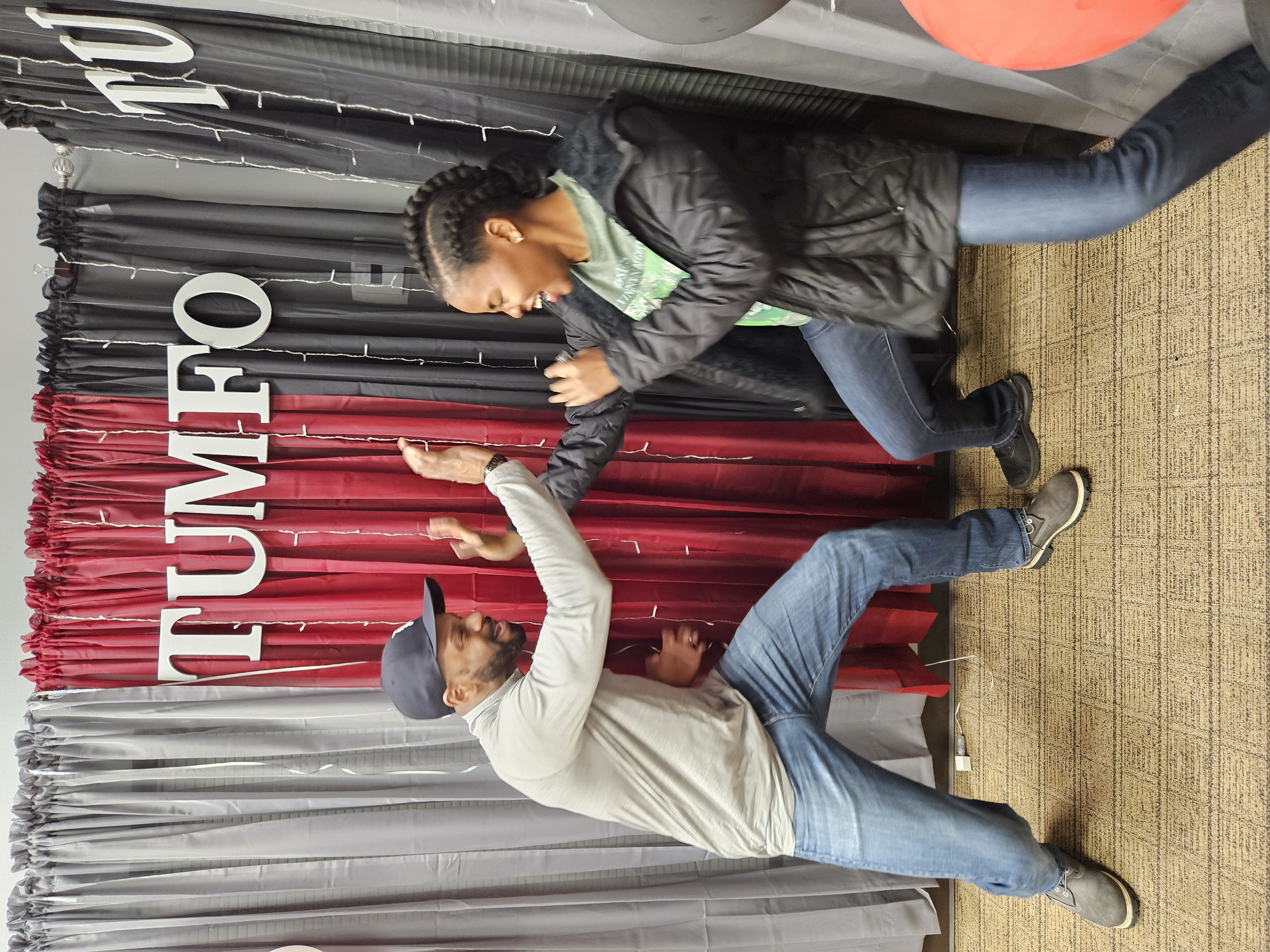 Father and son training together at Tumfo Tu with TUMFO banner in background